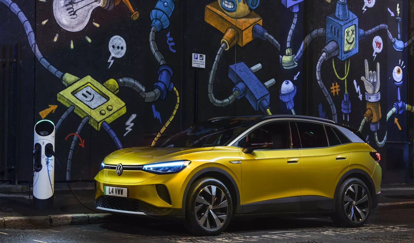 Volkswagen ID4 electric car parking on street next to graffiti wall